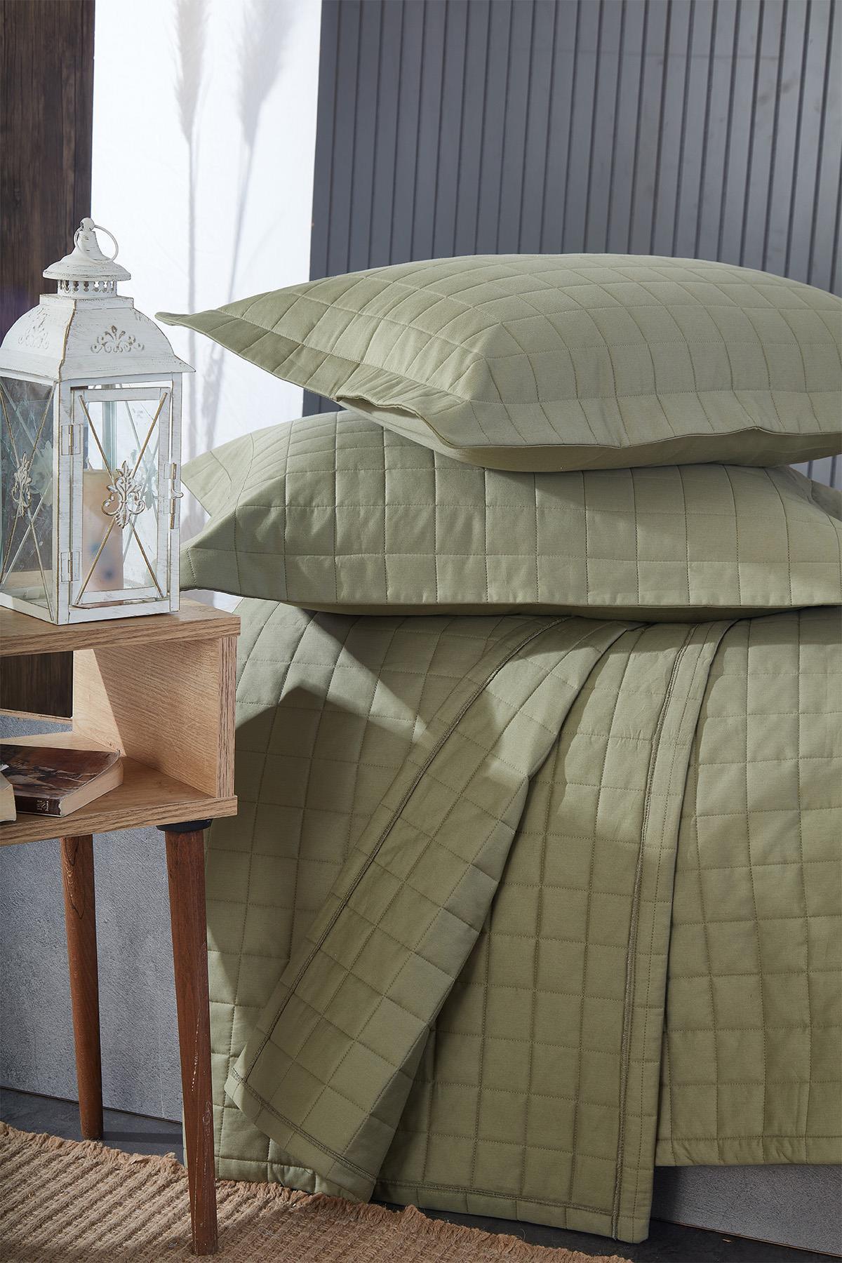 Yeşil kapitoneli çift kişilik yatak örtüsü ve yastıklar, modern yatak odası dekoru